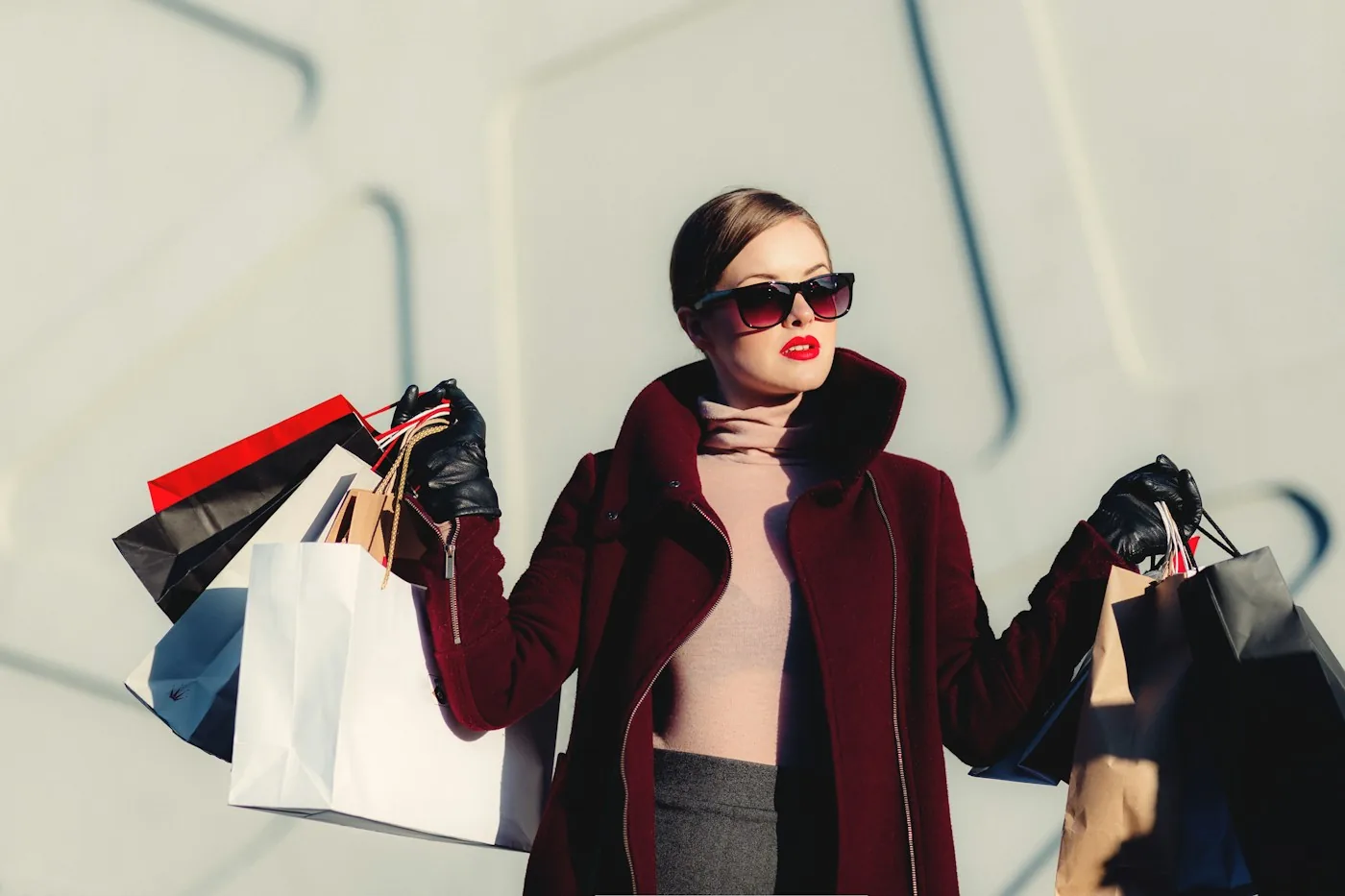 A woman wearing a burgundy coat and sunglasses