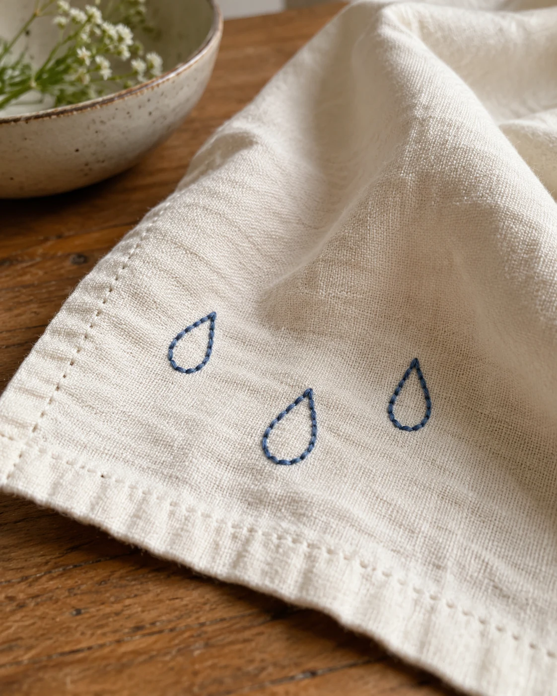Illustrative concept: three stitched raindrops.